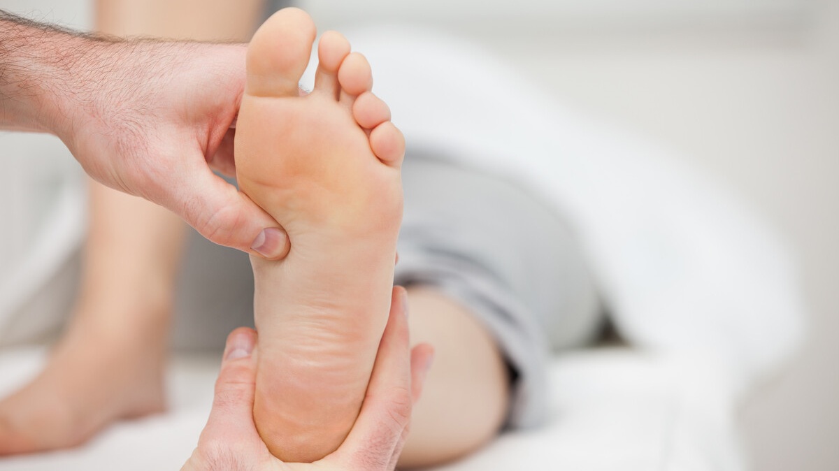 Reflessologia plantare con pressioni sui punti riflessi del piede